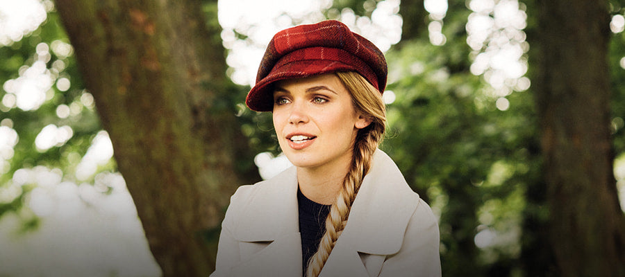 A woman wearing a flat cap, smiling